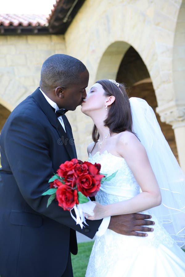 attractive-interracial-wedding-couple-kissing-5441628.jpg