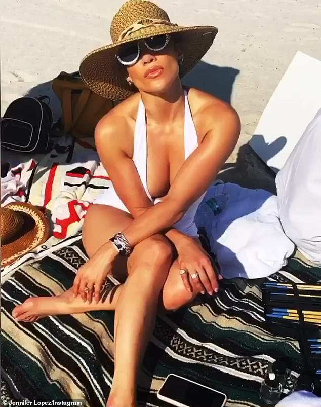 Basking: Lopez flaunted substantial cleavage while taking a well-deserved break to sun herself on a beach in Miami on Wednesday